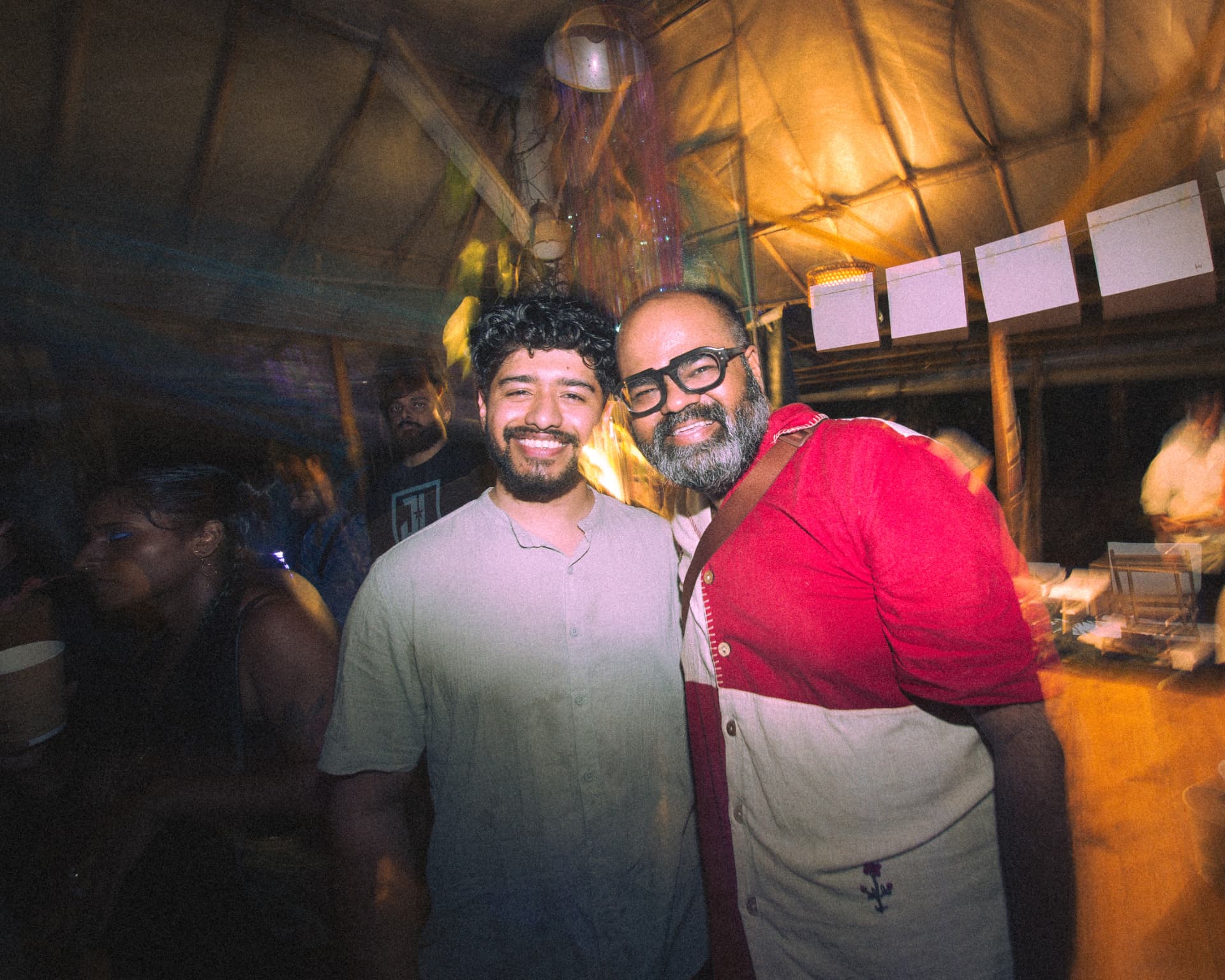 Two friends smiling together at the venue bar