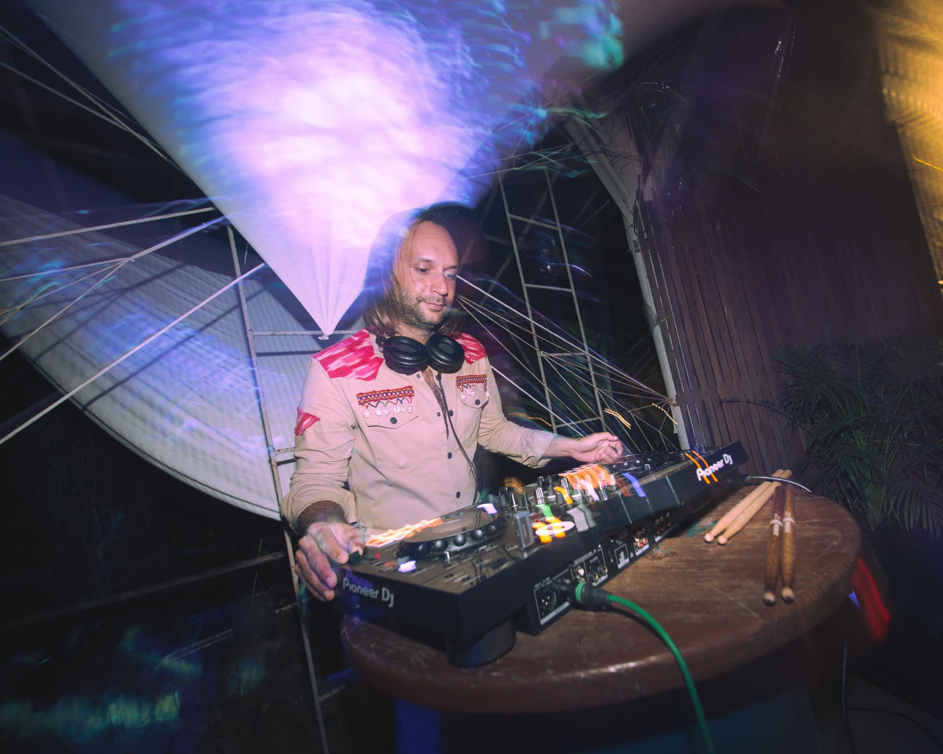 DJ mixing beneath a projection screen