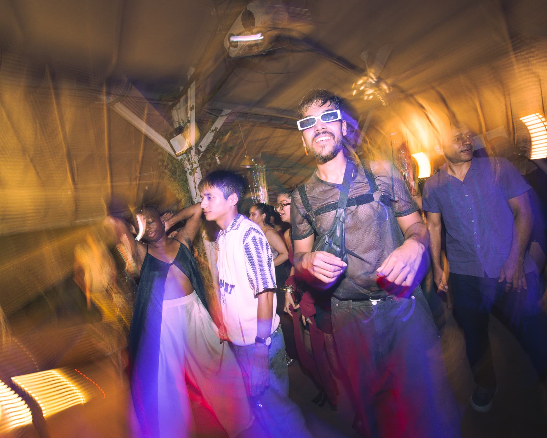 Crowd dancing together in warm amber light