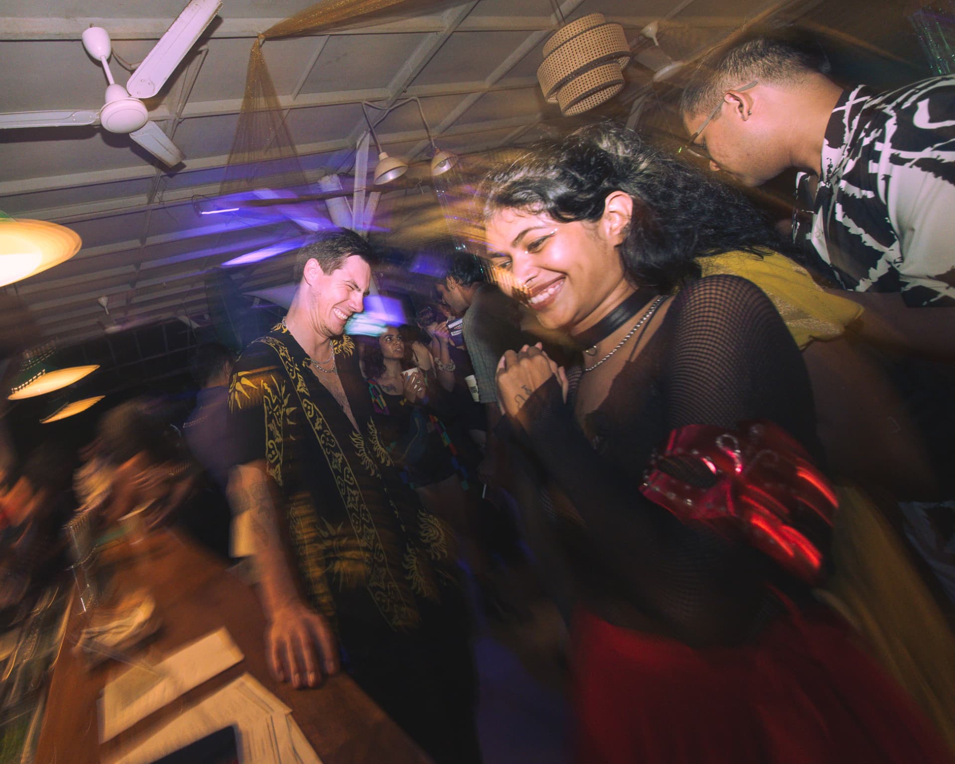 Couple laughing mid-dance in a blur of movement