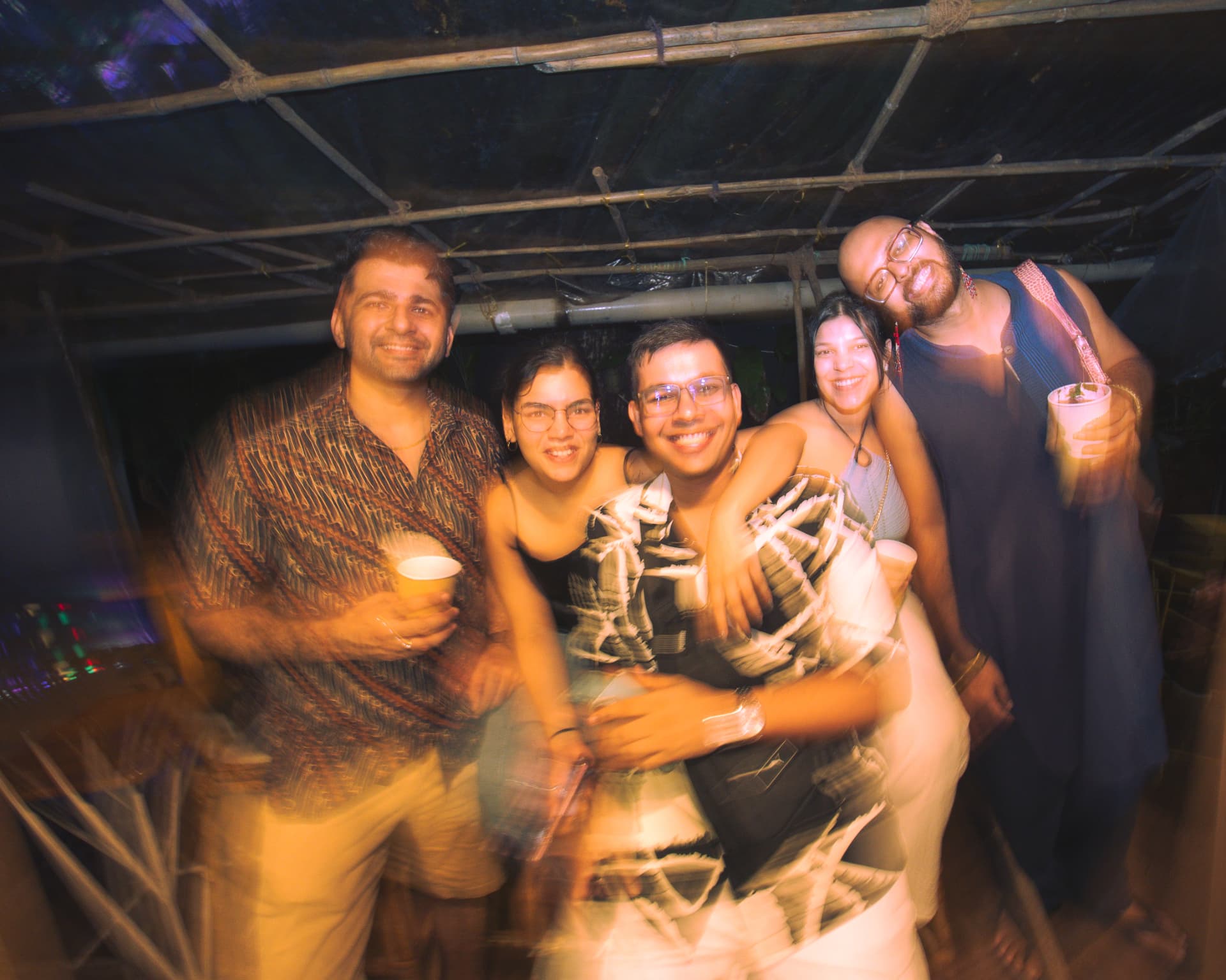 Five friends hugging for a group photo at the festival