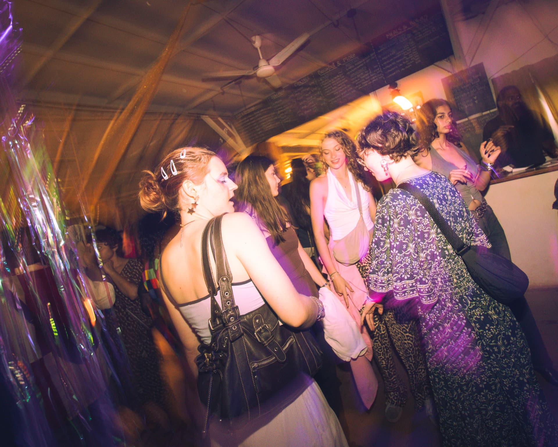 Group of friends dancing beside iridescent streamers