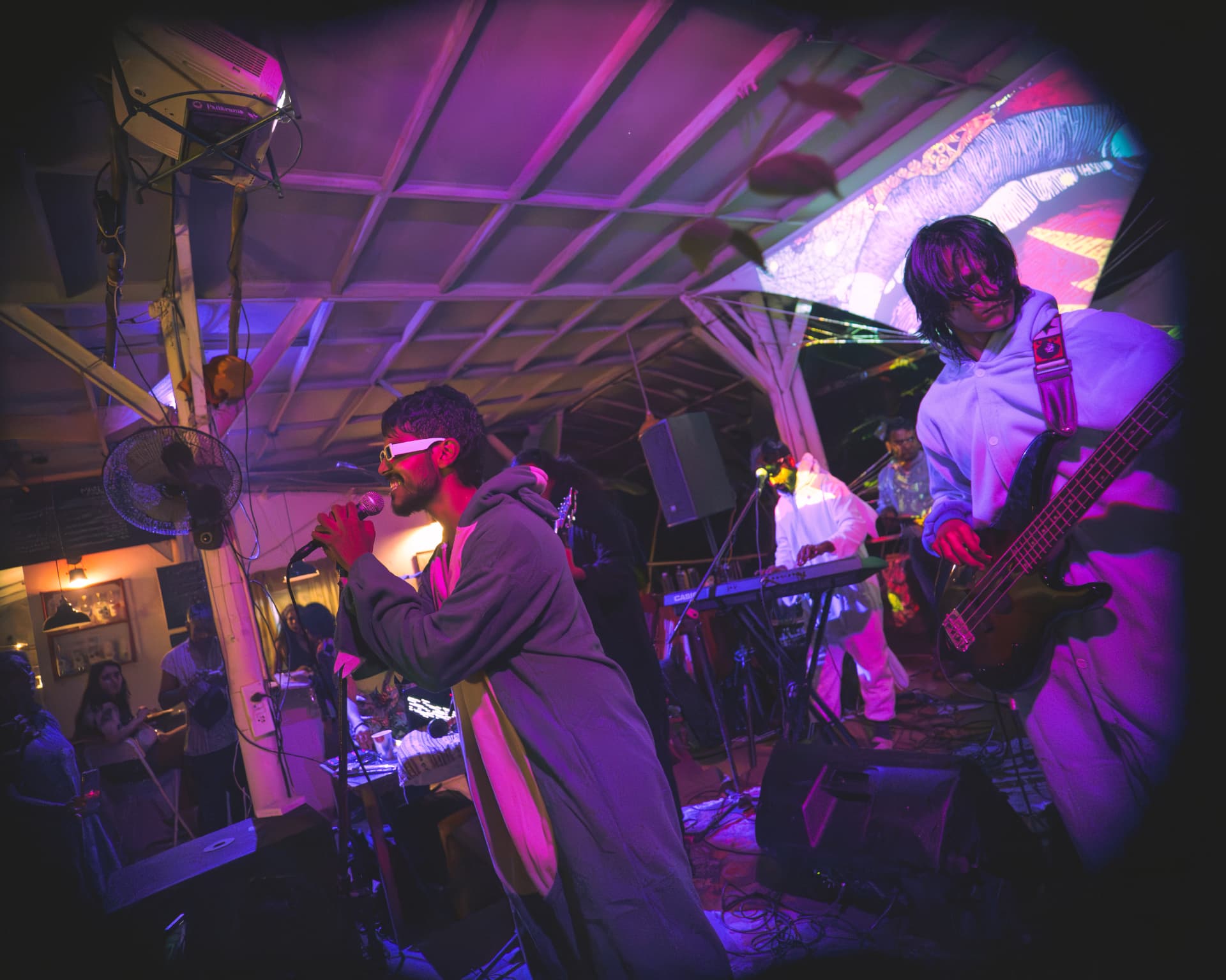 Band performing in kigurumi outfits under magenta light
