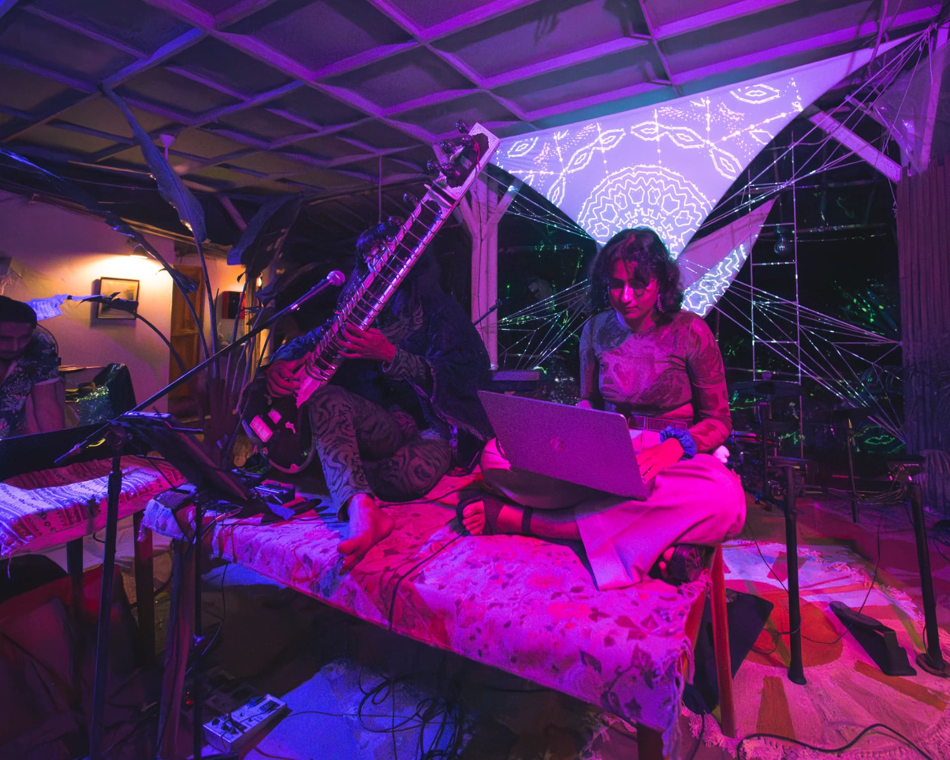 Sitar player and live electronic producer sharing a decorated stage